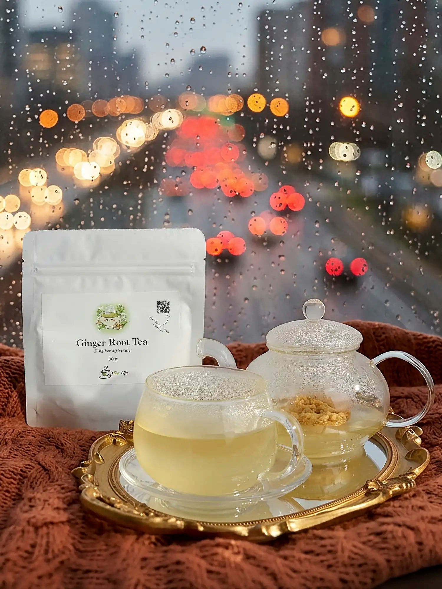 Tea set with a teapot and cup on a tray, featuring a package of Ginger Root Tea, against a blurred cityscape background.